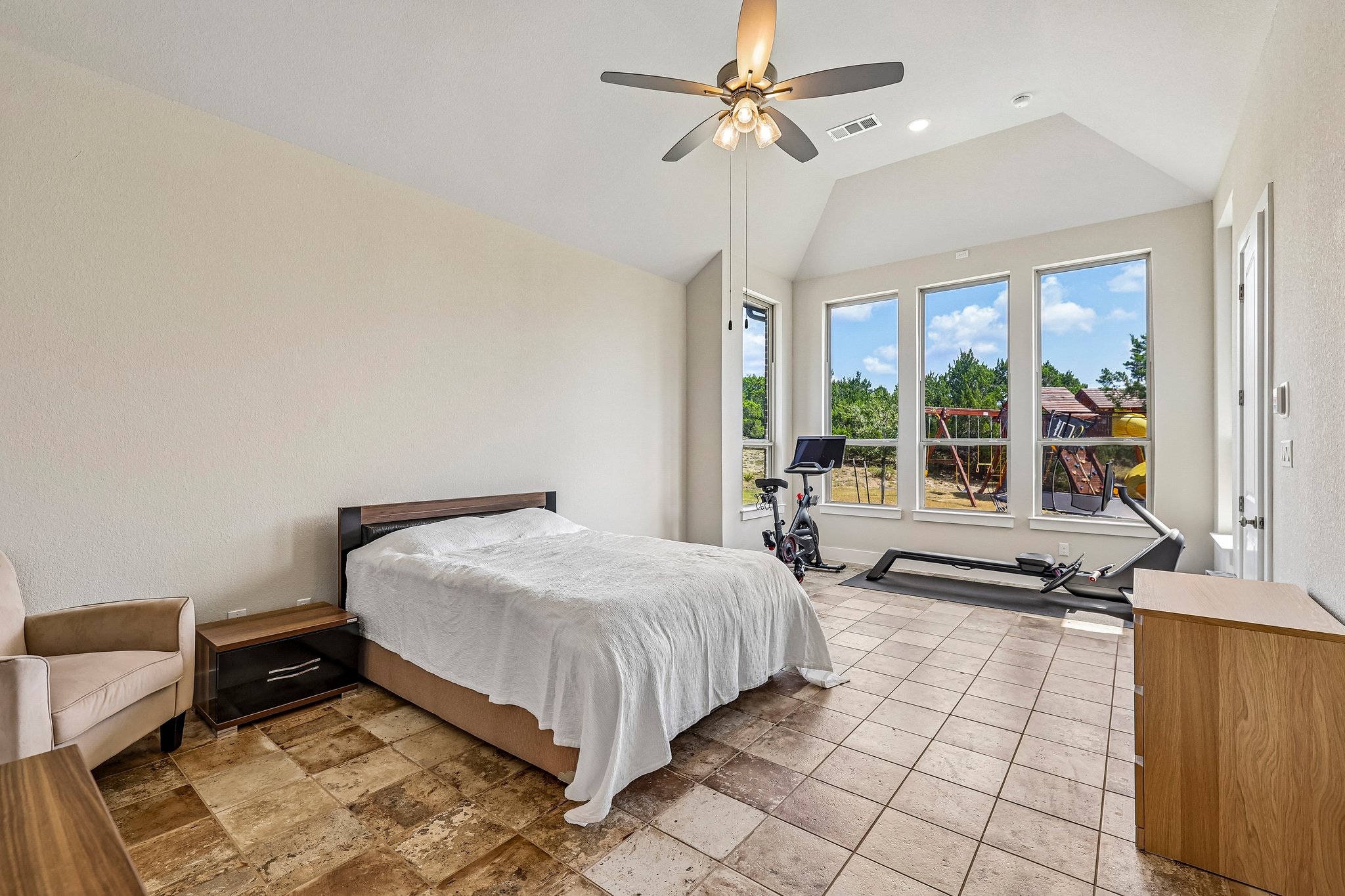 1705 Parten Rnch Parkway Austin, TX 78737 - Photo 24 of 39 An airy bedroom with vaulted ceilings offers tile flooring and abundant natural light.