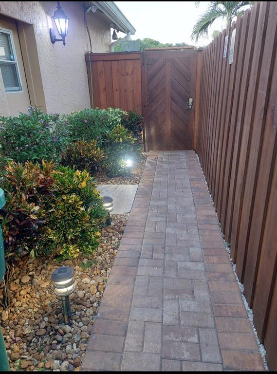 5770 Northwest 191st Terrace Hialeah, FL 33015 - Photo 4 of 17 a view of a pathway with a wooden fence