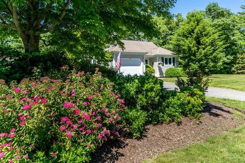 a front view of a house with a garden and plants