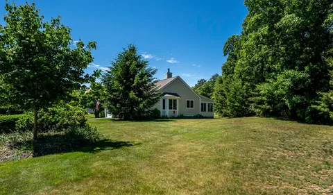 a front view of a house with a yard and fountain