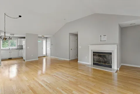 a view of empty room with wooden floor and windows
