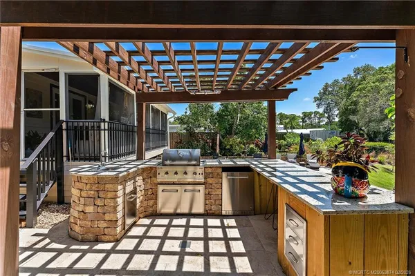 a view of swimming pool with lounge chair and dinning table under large trees