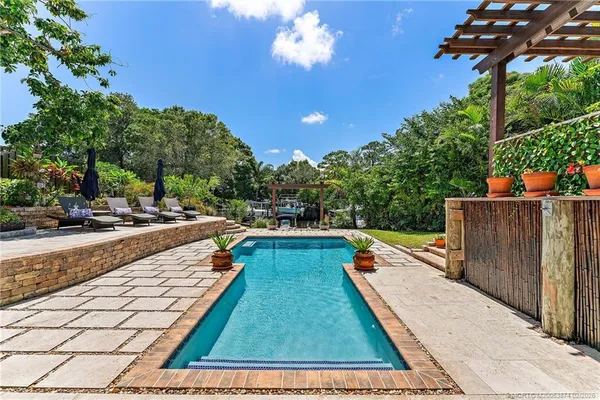 a view of swimming pool with outdoor seating and plants