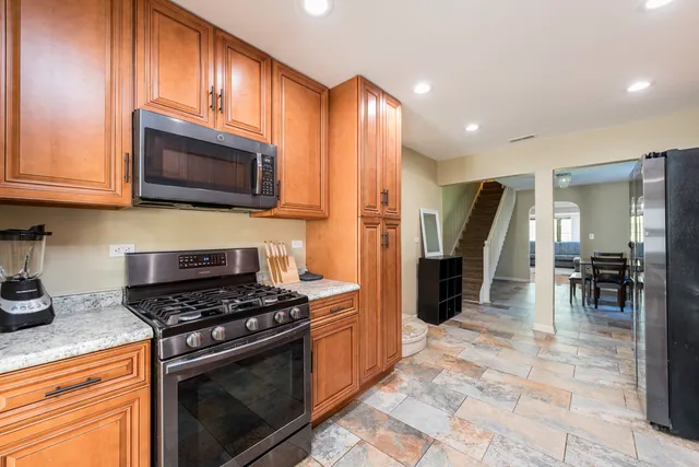 a kitchen with granite countertop a stove and a refrigerator