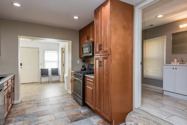 a view of a kitchen with a refrigerator a stove top oven and cabinets