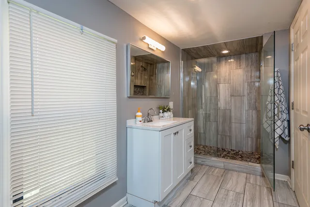 a bathroom with a sink a mirror and shower
