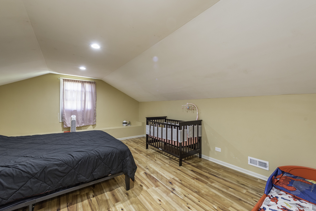 1700 Gideon Avenue Zion, IL 60099 - Photo 24 of 33 a spacious bedroom with a bed and wooden floor