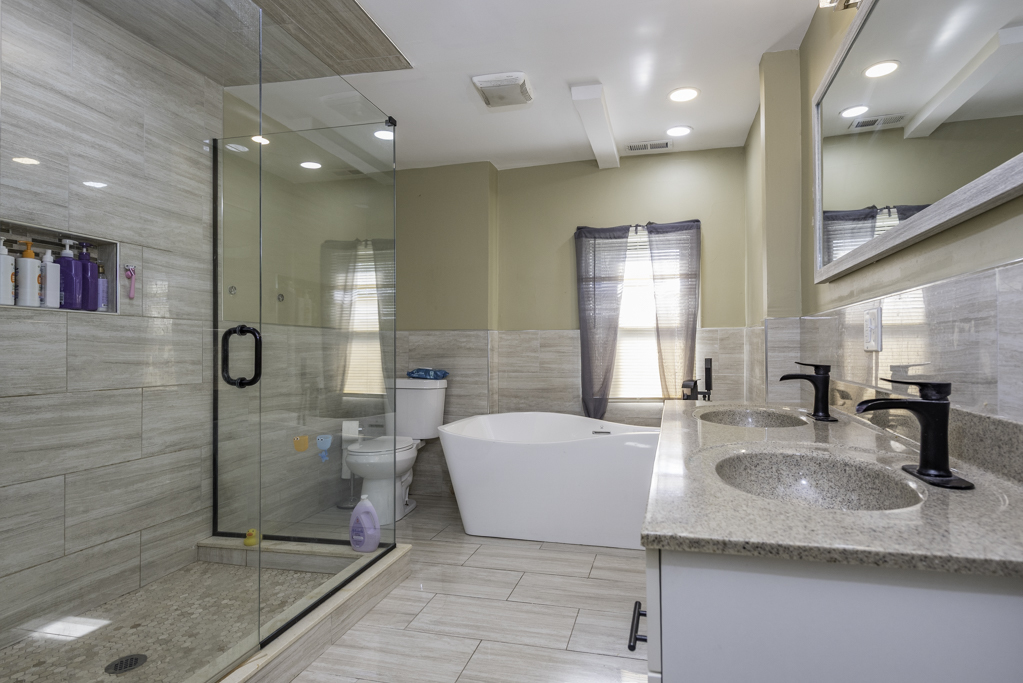 1700 Gideon Avenue Zion, IL 60099 - Photo 26 of 33 a bathroom with a granite countertop sink a toilet a mirror and shower