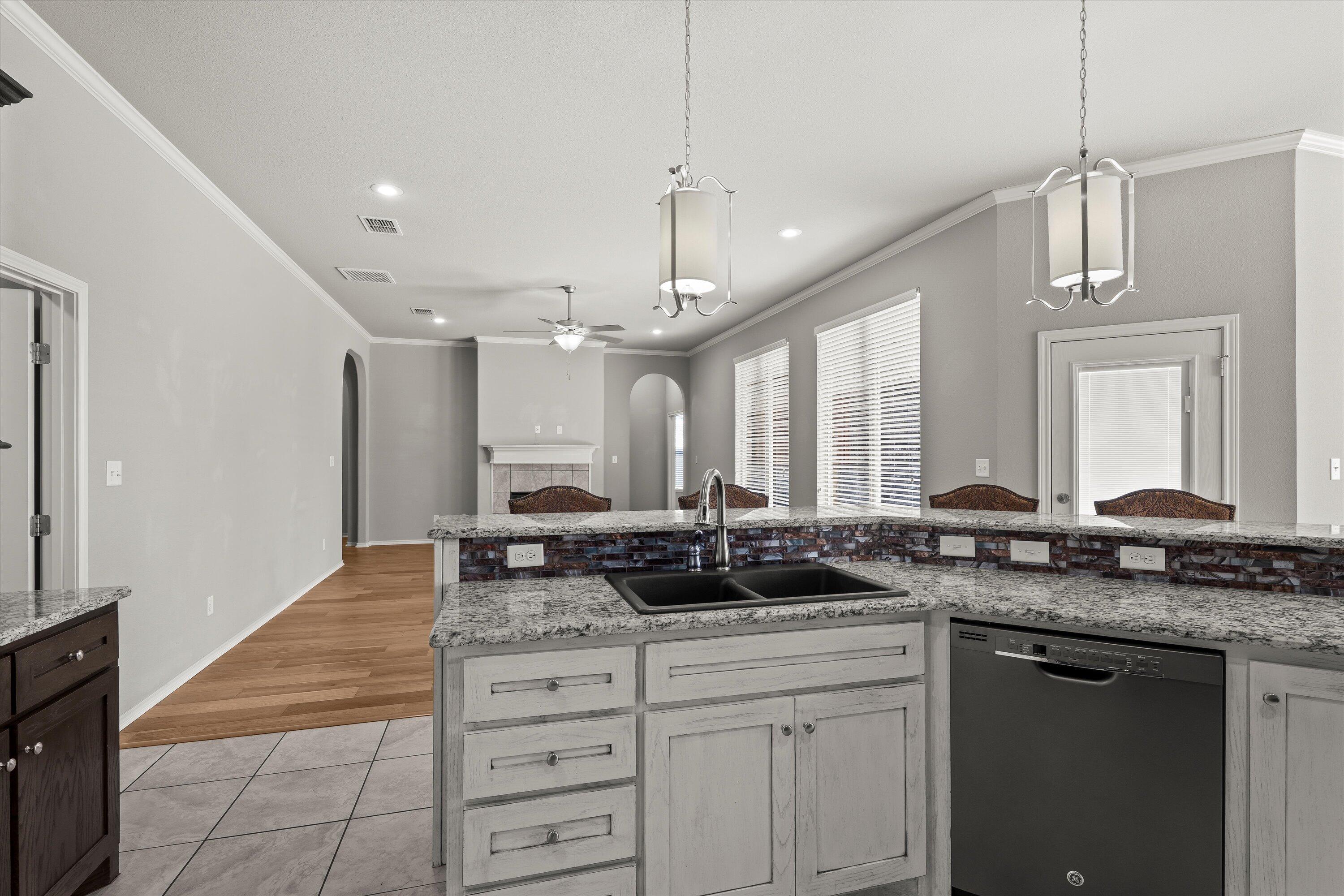 9616 Kline Avenue Lubbock, TX 79424 - Photo 13 of 33 a kitchen with granite countertop a sink a counter top space and cabinets