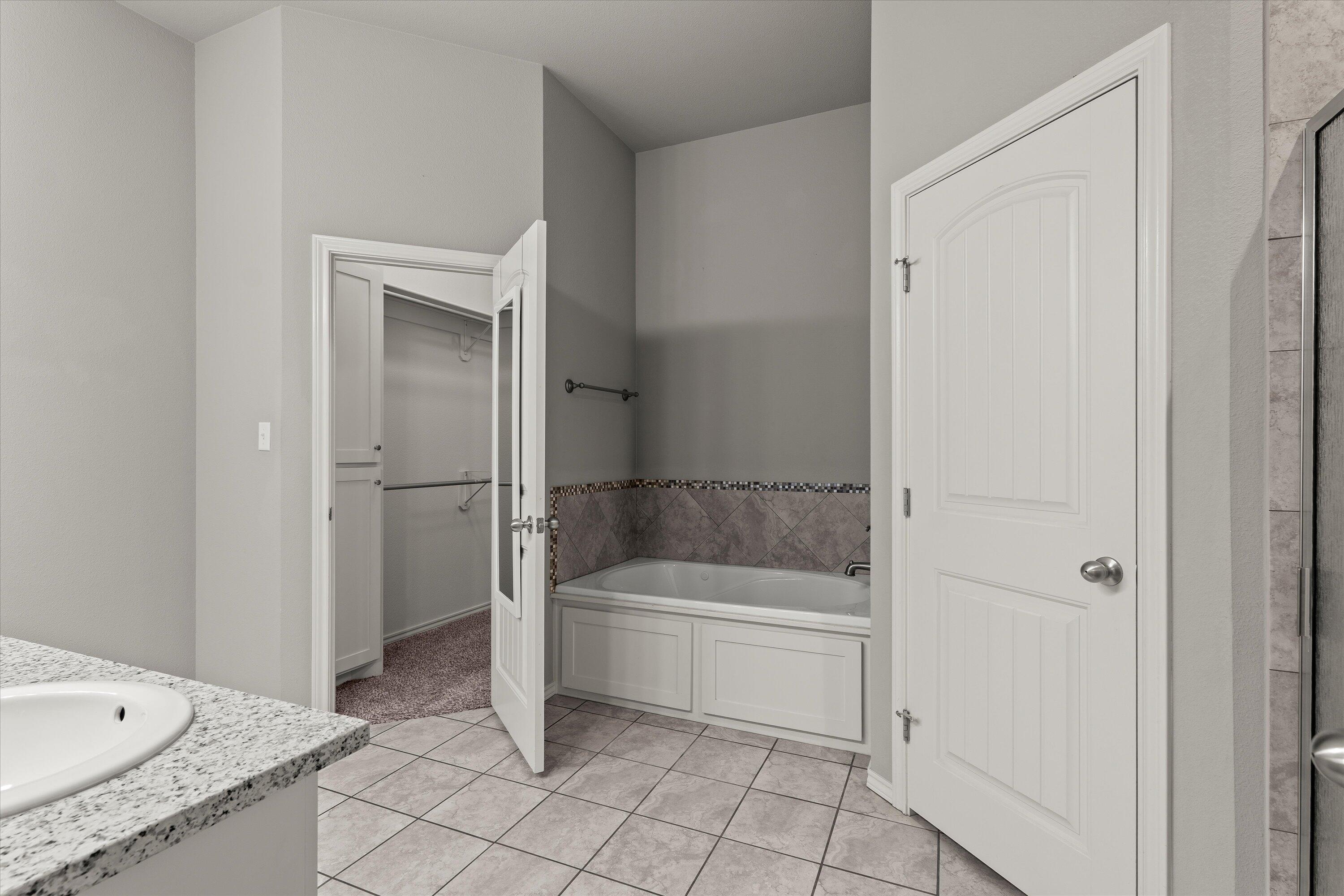 9616 Kline Avenue Lubbock, TX 79424 - Photo 19 of 33 a bathroom with a tub and a shower