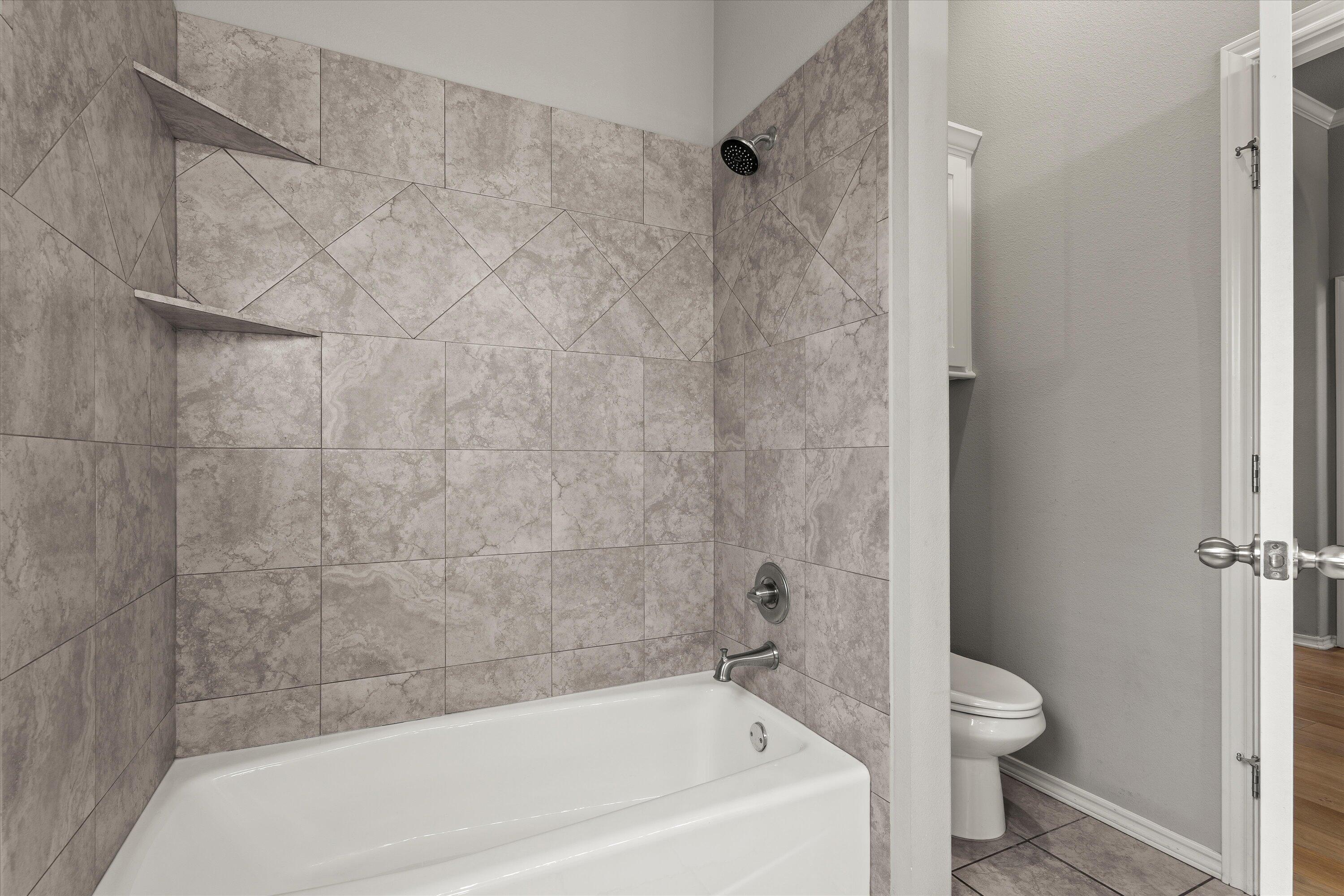 9616 Kline Avenue Lubbock, TX 79424 - Photo 25 of 33 a bathroom with a bathtub and a toilet