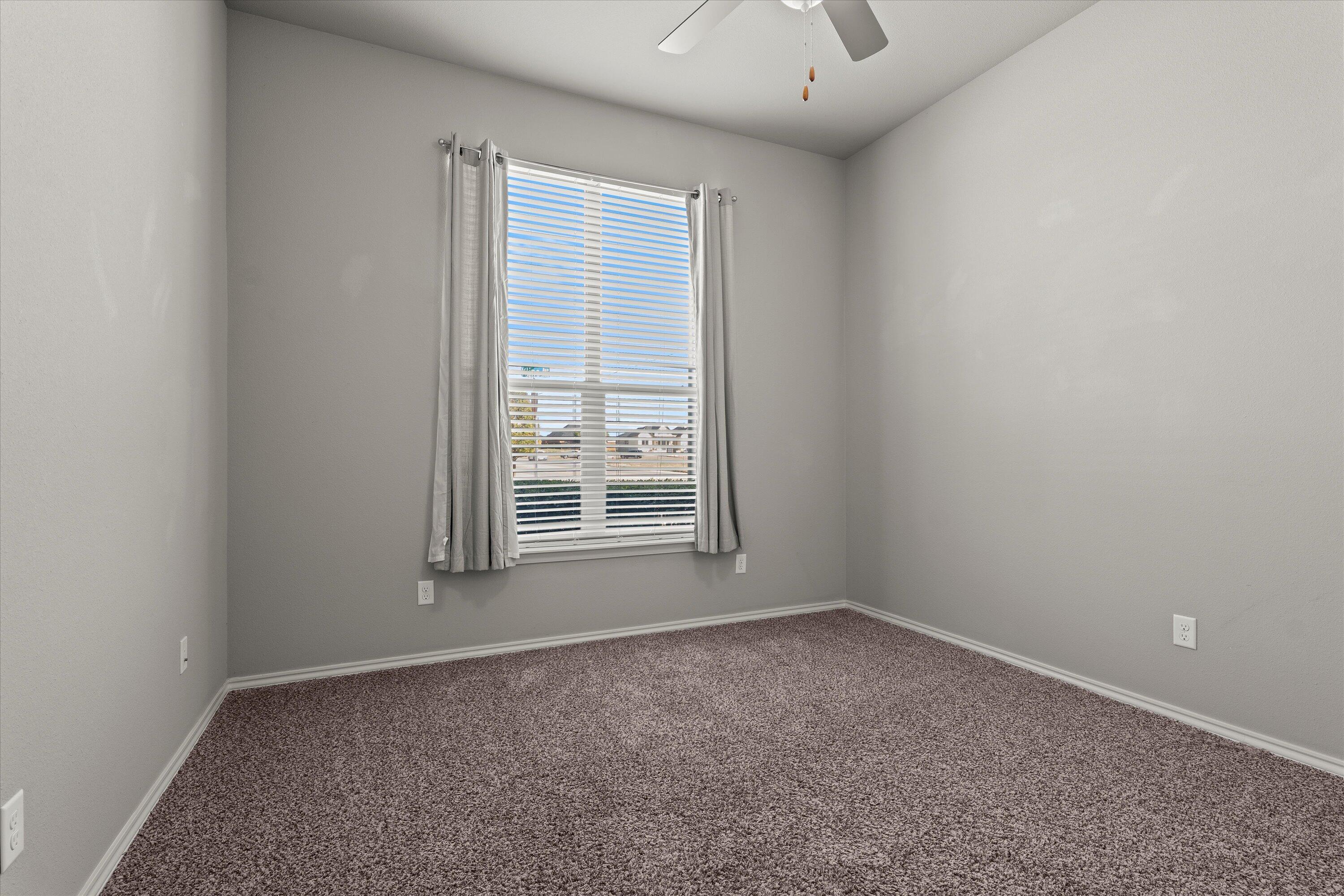 9616 Kline Avenue Lubbock, TX 79424 - Photo 26 of 33 an empty room with a window and a ceiling fan