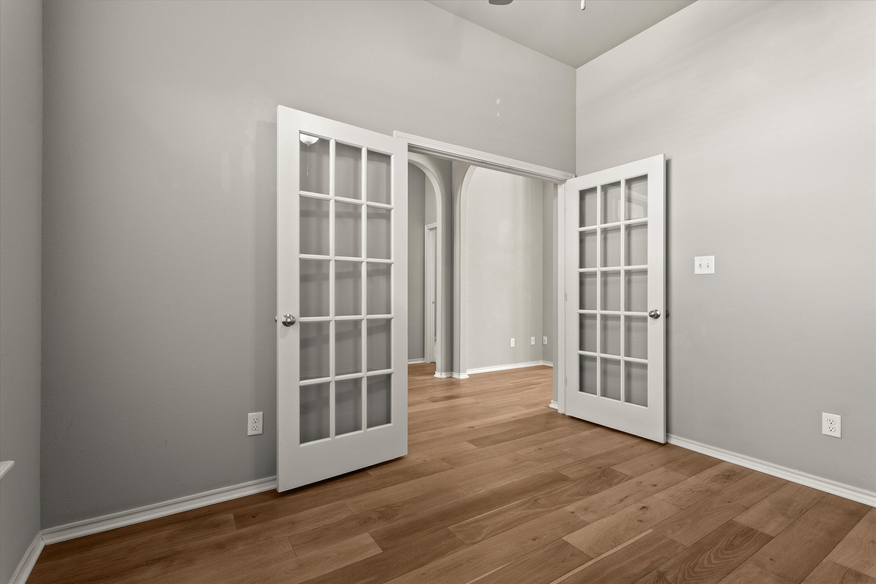 9616 Kline Avenue Lubbock, TX 79424 - Photo 6 of 33 an empty room with wooden floor and windows