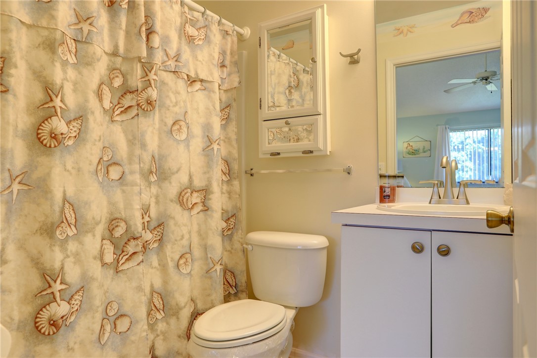 9635 Riverside Drive, Unit 4 Sebastian, FL 32958 - Photo 18 of 34 a bathroom with a sink a toilet and shower curtain