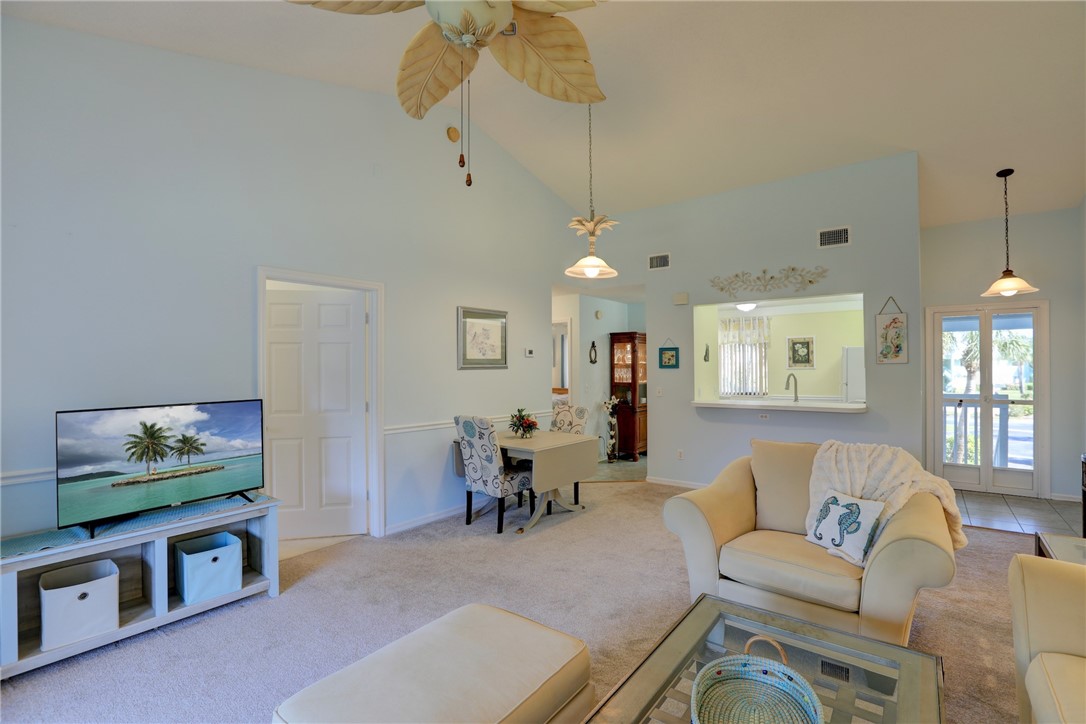 9635 Riverside Drive, Unit 4 Sebastian, FL 32958 - Photo 8 of 34 a living room with furniture piano and a chandelier