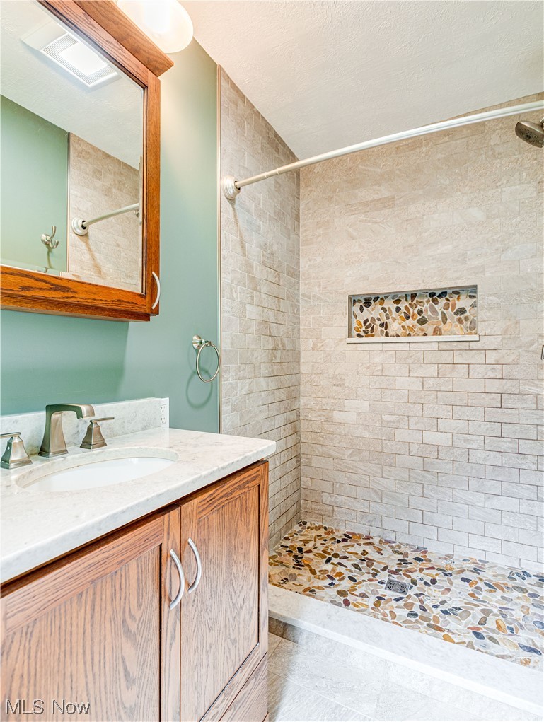 940 North Hametown Road Akron, OH 44333 - Photo 23 of 34 Bathroom featuring a tile shower and vanity