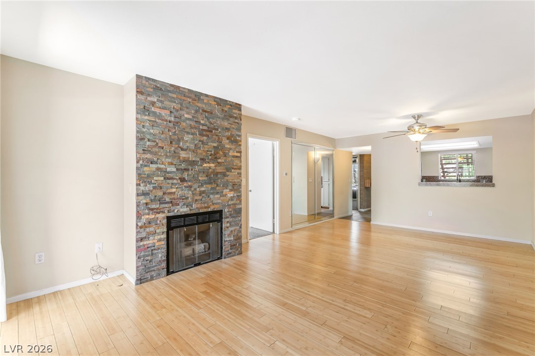 1901 Rio Canyon Court, Unit 102 Las Vegas, NV 89128 - Photo 9 of 23 Warm wood floors and a striking stacked stone fireplace define this comfortable living space.