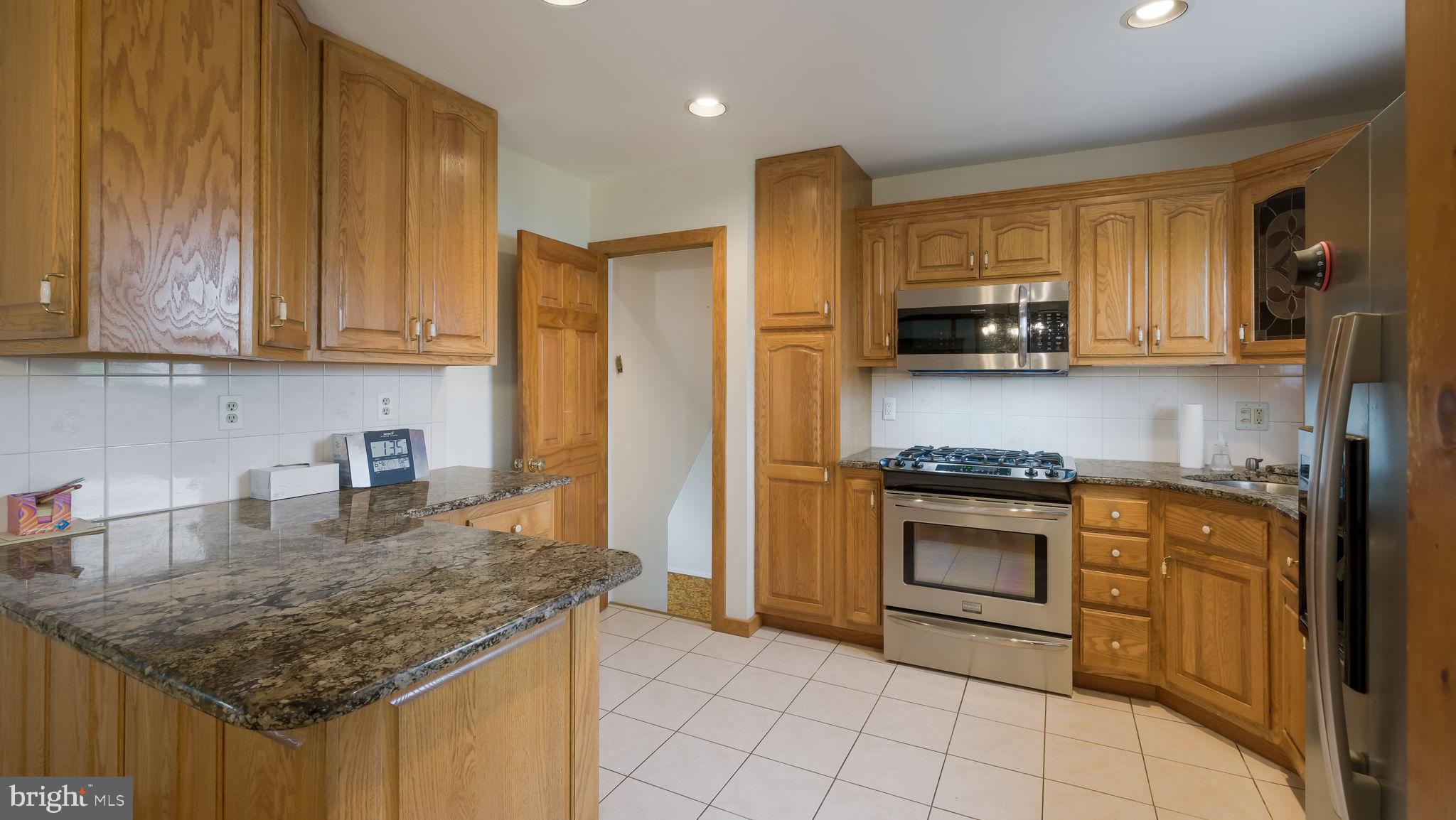 1243 Tulip Road Warminster, PA 18974 - Photo 11 of 33 a kitchen with stainless steel appliances granite countertop a stove a sink and a refrigerator