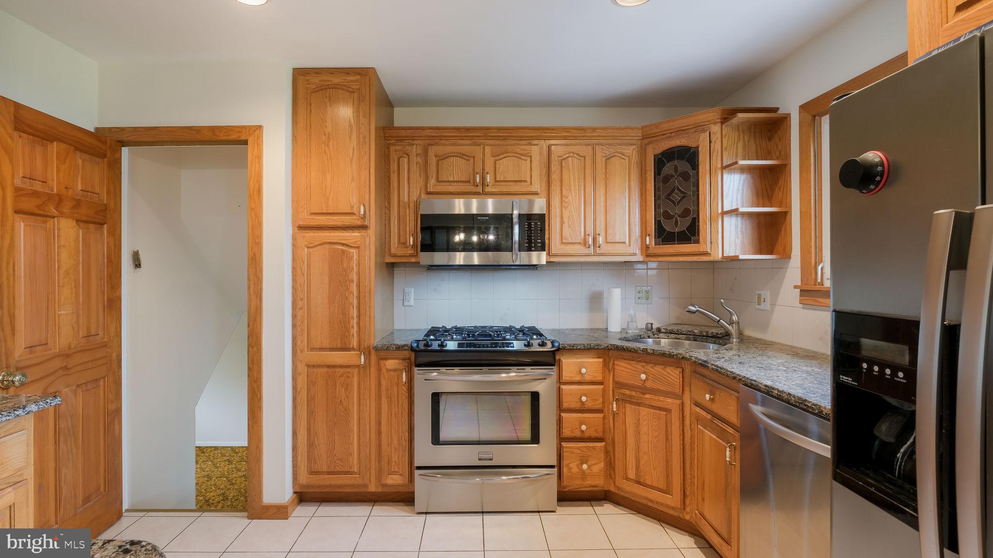 1243 Tulip Road Warminster, PA 18974 - Photo 13 of 33 a kitchen with stainless steel appliances granite countertop a stove a sink and a refrigerator