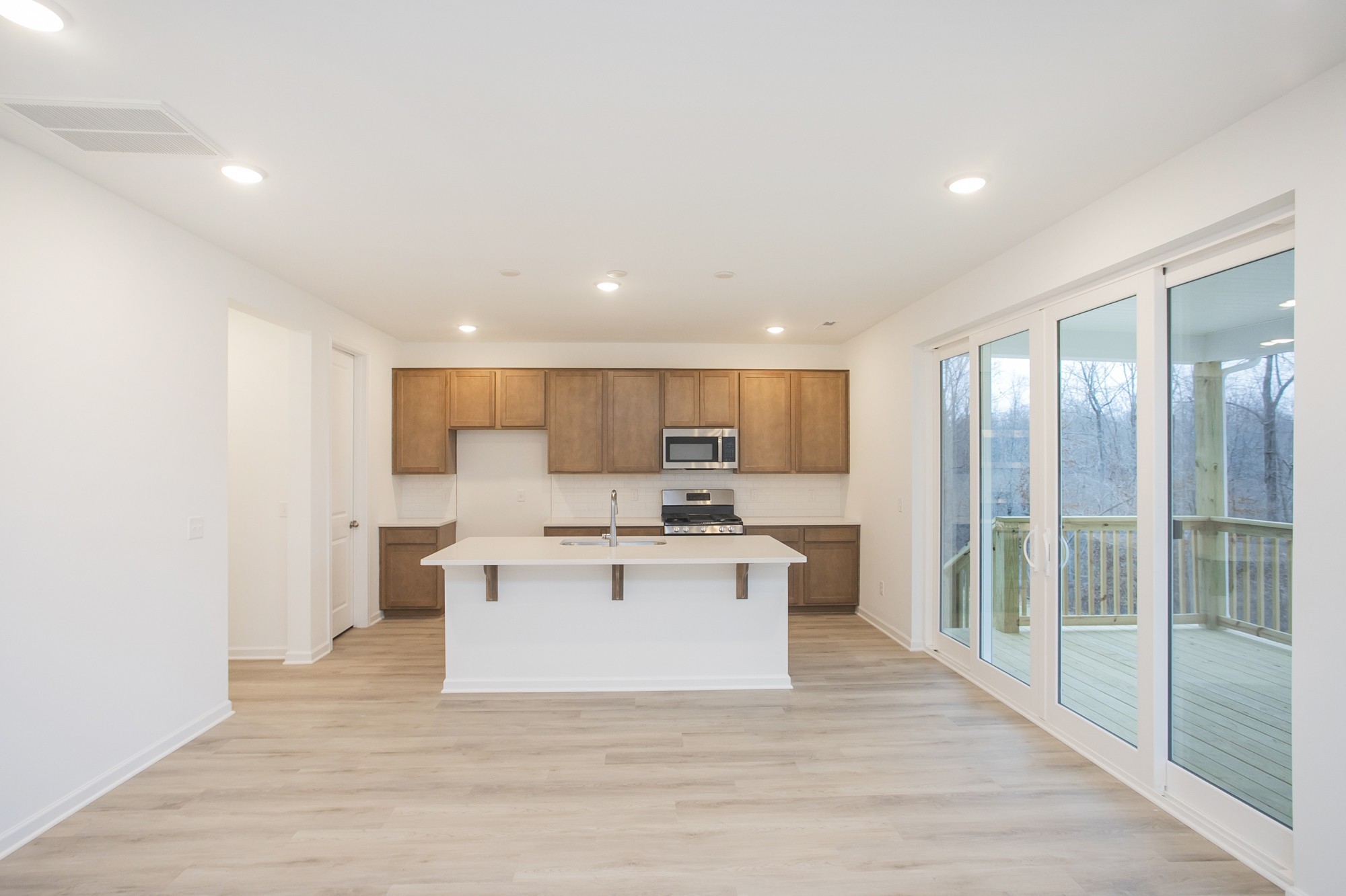 625 Maple Bend Dickson, TN 37055 - Photo 21 of 45 a view of a kitchen with kitchen island a sink wooden floor and a refrigerator
