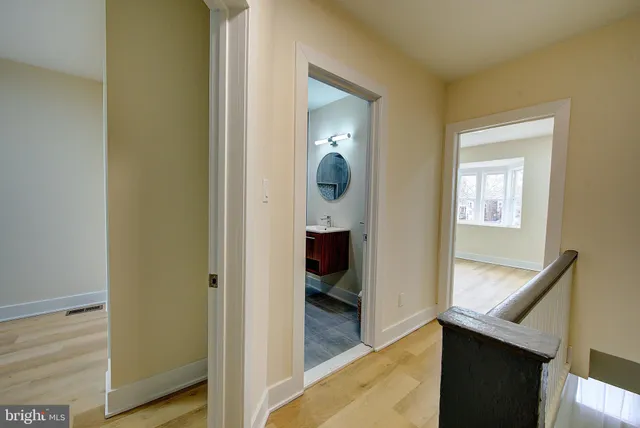 a view of a hallway and bathroom with wooden floor