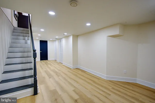 a view of a hallway with stairs and a wooden floor