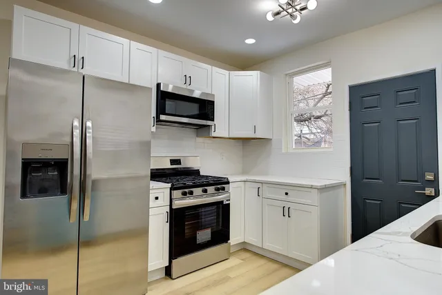 a kitchen with stainless steel appliances kitchen island granite countertop a stove a sink and a refrigerator