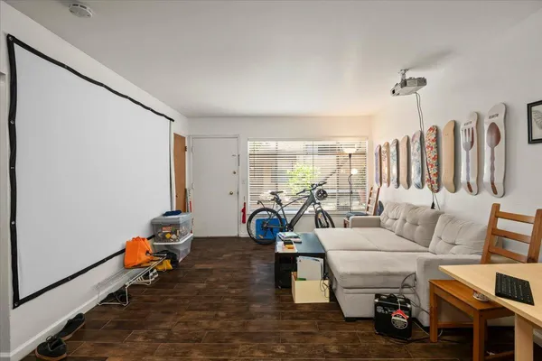 a living room with furniture a window and a wooden floor
