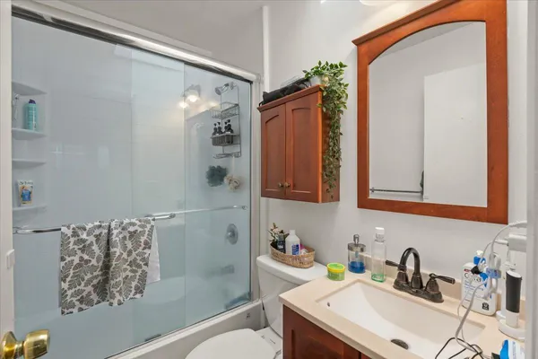 a bathroom with a sink a toilet and shower