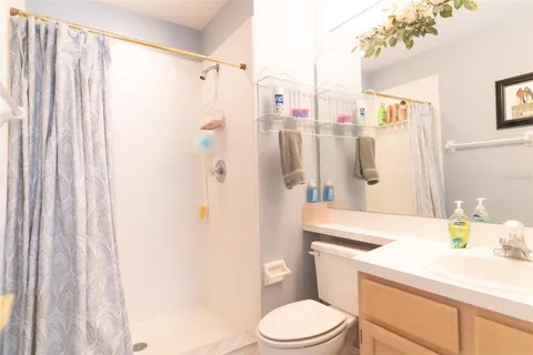 a bathroom with a sink a toilet and shower curtain