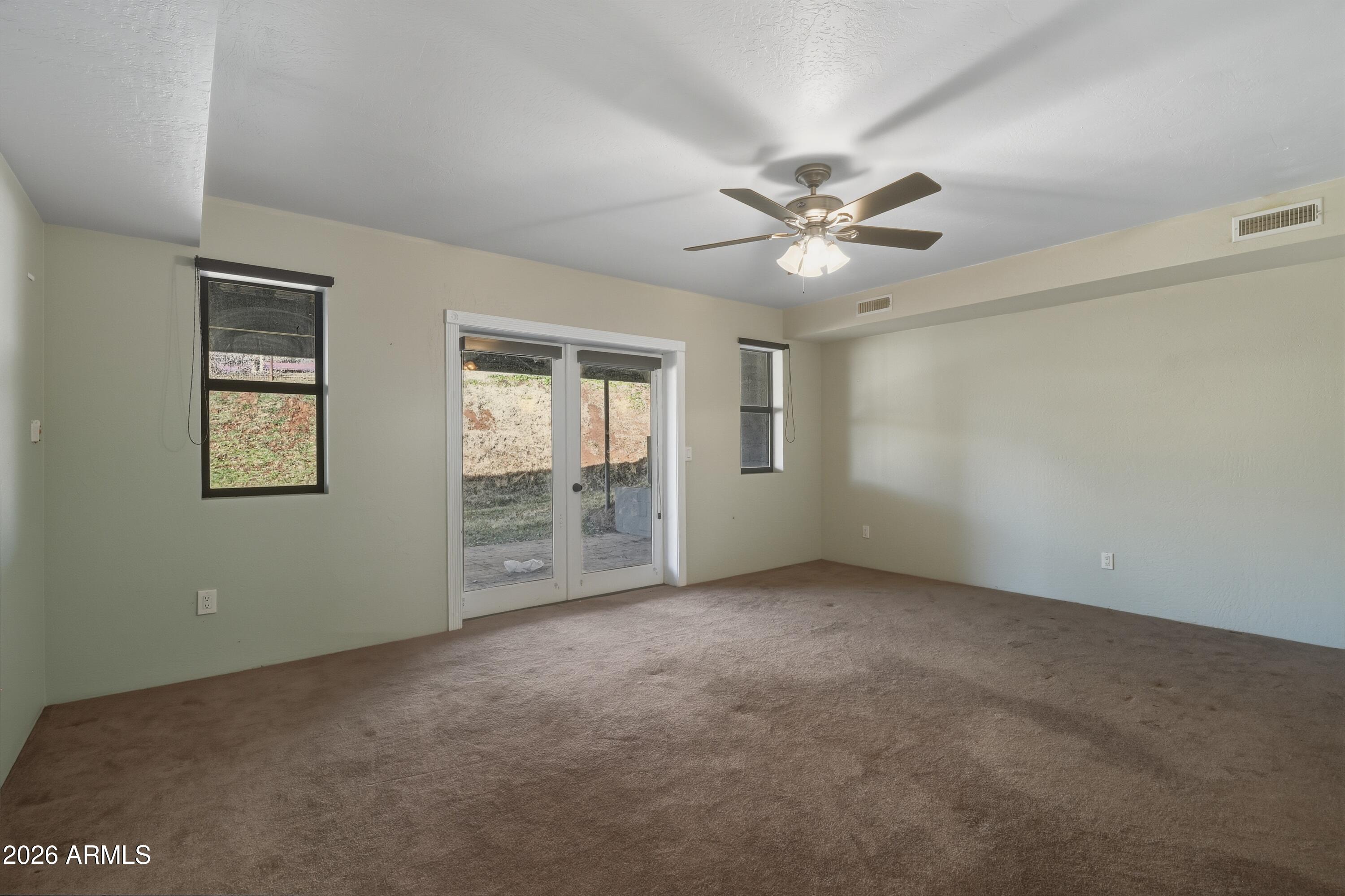 6475 Pine Cone Trail Pine, AZ 85544 - Photo 27 of 51 an empty room with chandelier fan and windows