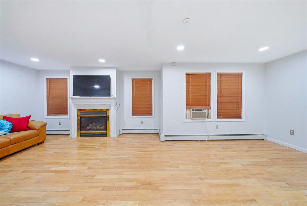 39 Hawthorne Street, Unit 39 Boston, MA 02119 - Photo 4 of 33 a view of an empty room with a fireplace and a window
