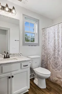 a bathroom with a toilet a sink and a window