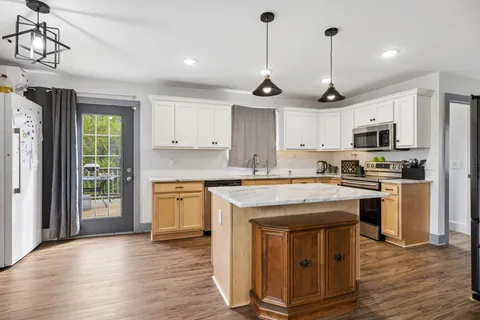 a kitchen with stainless steel appliances granite countertop a stove a sink and a refrigerator