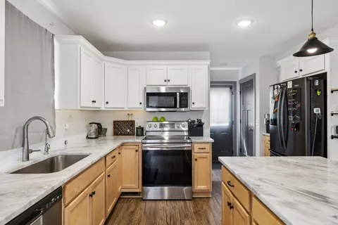a kitchen with stainless steel appliances granite countertop a sink stove and refrigerator