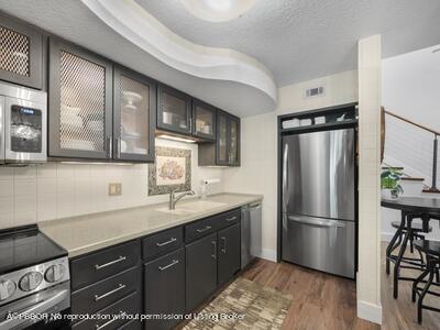 382 Golfview Road, Unit H North Palm Beach, FL 33408 - Photo 9 of 22 a kitchen with a refrigerator a sink and wooden floor