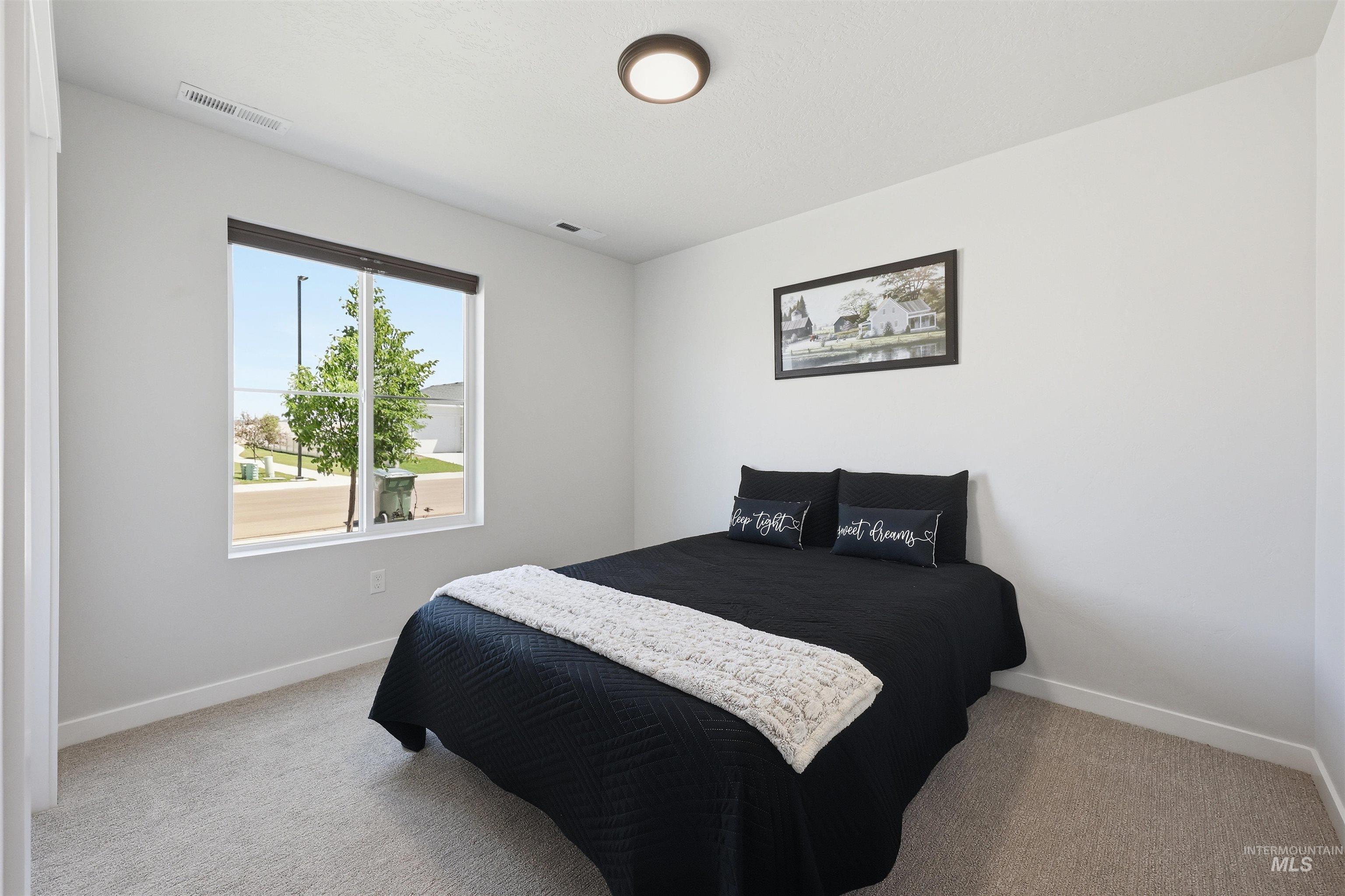 3811 West Maypearl Street Meridian, ID 83642 - Photo 9 of 39 Bedroom featuring a large window, soft carpet flooring, light gray walls, white baseboards, and a contemporary ceiling light fixture