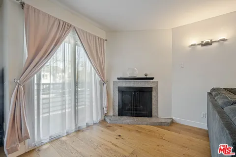a view of an empty room with a fireplace and a window