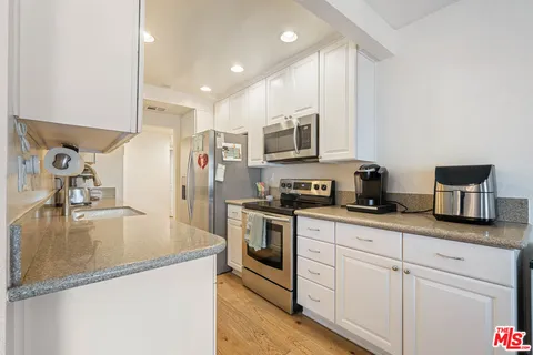 a kitchen with kitchen island a counter top space appliances and cabinets