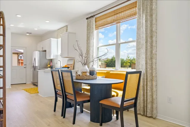 a dining room with furniture potted plants and wooden floor