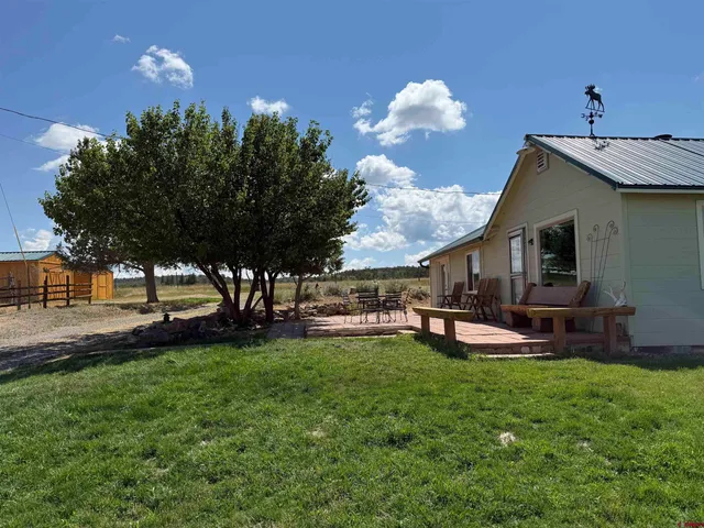 a view of a house with backyard porch and sitting area