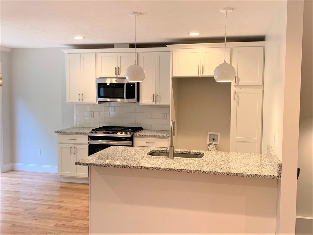 11 Shaker Road, Unit B Ayer, MA 01432 - Photo 3 of 16 a kitchen with granite countertop a refrigerator and a sink