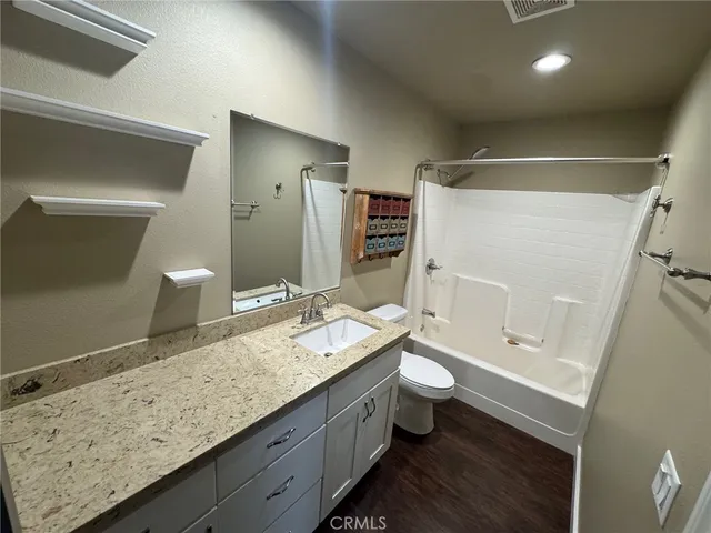 a bathroom with a granite countertop sink toilet and shower