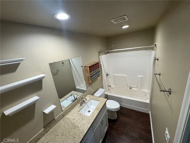 a bathroom with a granite countertop sink toilet and shower