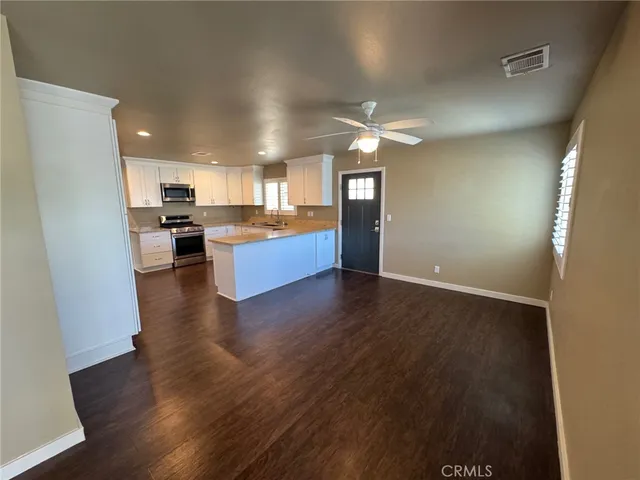 a view of a kitchen with wooden floor and a kitchen