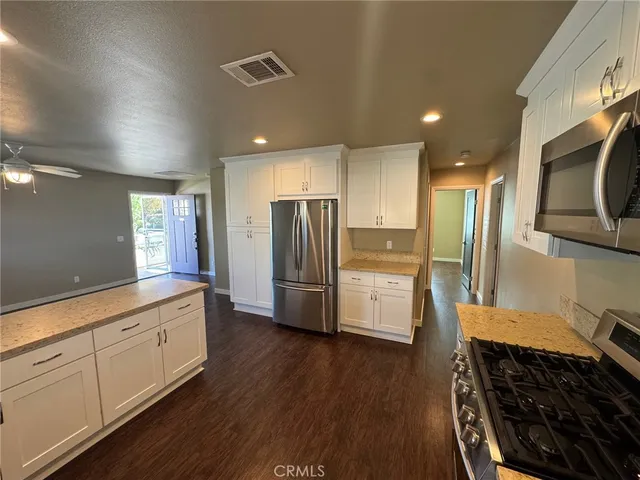 a kitchen with stainless steel appliances a refrigerator and a stove top oven