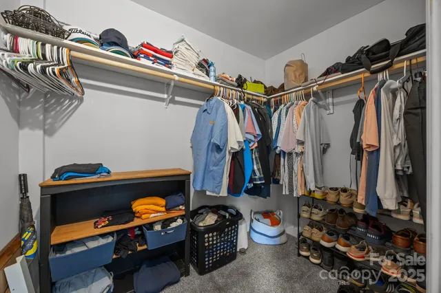 a view of walk in closet with clothes and shoes
