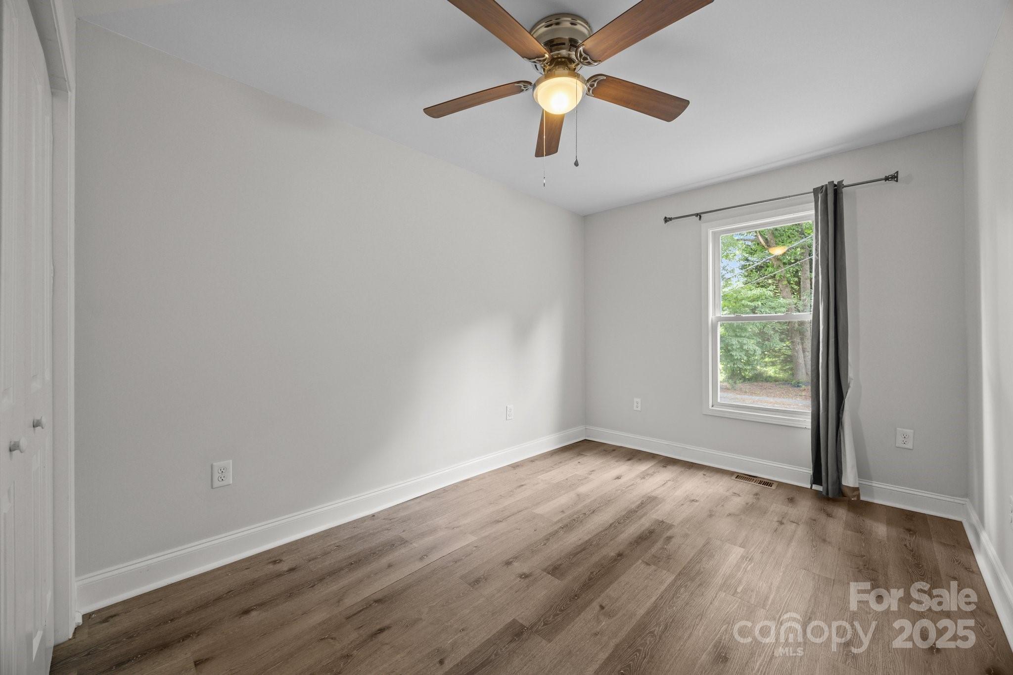 5371 Davidson Road Davidson, NC 28036 - Photo 19 of 27 an empty room with wooden floor fan and windows