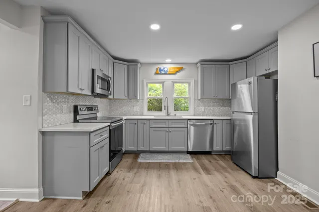 a kitchen with a refrigerator a sink and a stove top oven