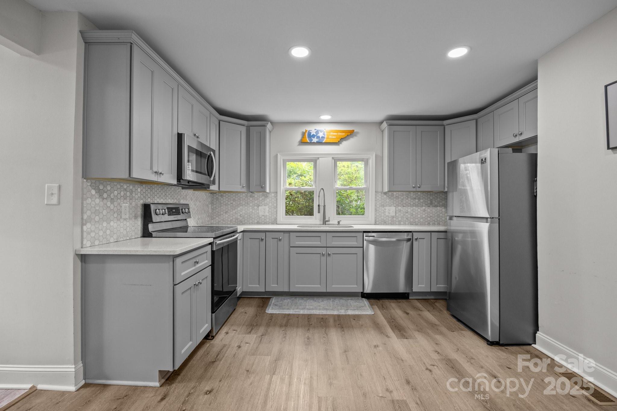 5371 Davidson Road Davidson, NC 28036 - Photo 6 of 27 a kitchen with a refrigerator a sink and a stove top oven